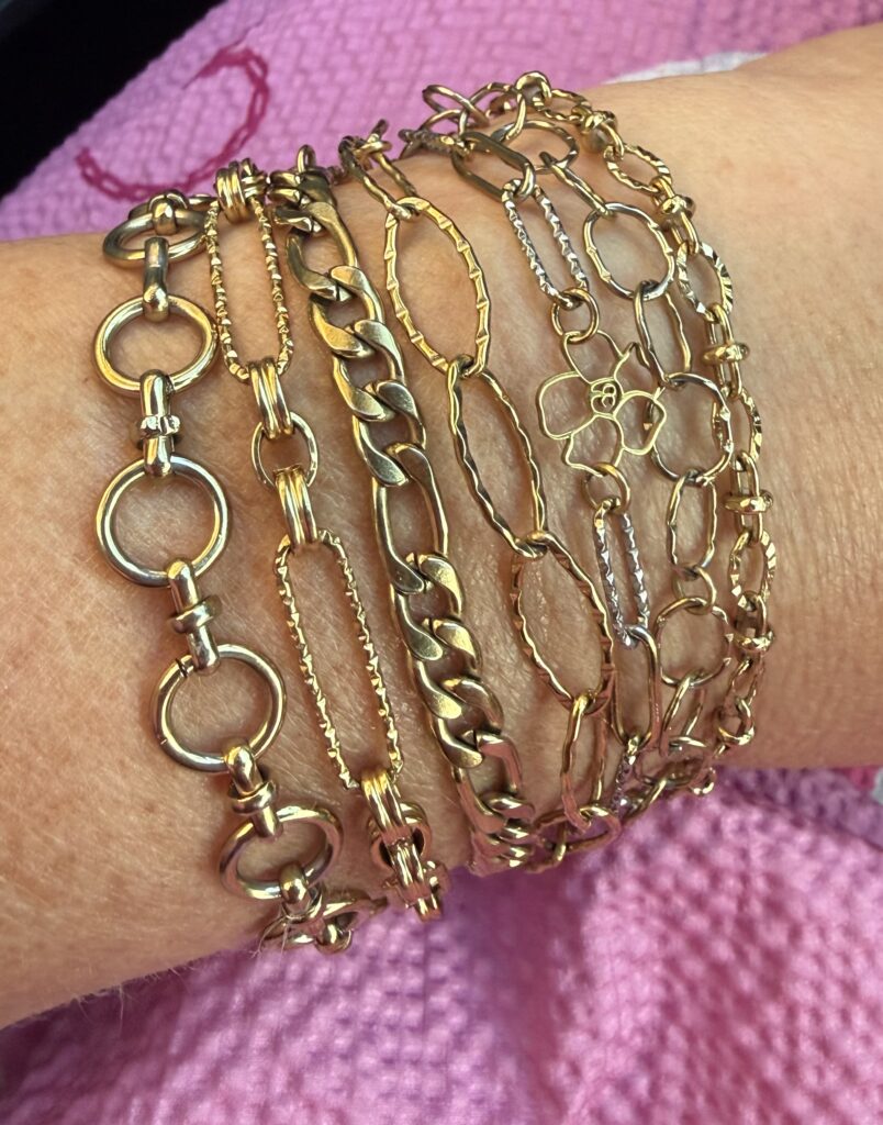 Stack of gold chain bracelets on a wrist