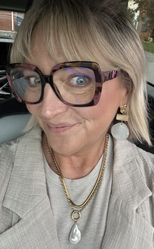 Jennifer Lippy smiling, wearing layered gold necklaces